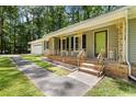 Charming home featuring a lovely porch with decorative railing, a vibrant green door, and a well-manicured lawn at 3957 Evans Drive Dr, Lithia Springs, GA 30122