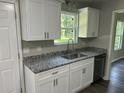 Stylish kitchen with granite counters, stainless steel sink, and ample cabinet space at 433 Rhett Dr, Loganville, GA 30052