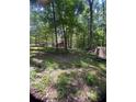 A red barn with gray roof is nestled on a lush lot, with wooded surroundings at 6394 Shore Dr, Douglasville, GA 30135