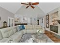 Inviting living room featuring vaulted ceilings, a cozy fireplace, and seamless flow to the kitchen at 1313 Fallsbrook Nw Ter, Acworth, GA 30101