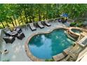 Enjoy resort-style living in this backyard oasis with a sparkling pool, hot tub and expansive patio at 1313 Fallsbrook Nw Ter, Acworth, GA 30101