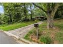 Long driveway leading to a secluded home amidst lush greenery at 4968 Twin Branches Way, Dunwoody, GA 30338