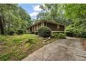 Side view of property featuring mature trees and manicured lawn at 4968 Twin Branches Way, Dunwoody, GA 30338