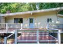 Charming home featuring an elevated deck and a serene, wooded backdrop at 504 N Little Victoria Rd, Woodstock, GA 30189