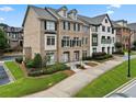 Attractive townhome showing brick and siding, a manicured lawn, and a driveway leading to the attached garage at 1165 Laurel Se Pl, Smyrna, GA 30080