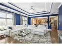 Bright living room with modern tray ceilings, large windows, hardwood floors, and an open view to the kitchen at 1165 Laurel Se Pl, Smyrna, GA 30080