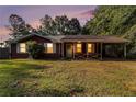 Charming single story home with a covered front porch and a spacious front yard at dusk at 3953 Dalhouise Ln, Decatur, GA 30034