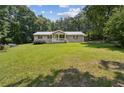 Single-story home with a metal roof and a sprawling, well-manicured front lawn at 146 Pine St, Covington, GA 30014