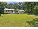 Single-story house surrounded by lush greenery and a well-kept lawn at 146 Pine St, Covington, GA 30014
