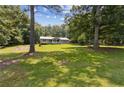 Single-story house with a big lawn, partially framed by trees under a cloudy sky at 146 Pine St, Covington, GA 30014