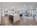 Open-concept living space featuring hardwood floors, modern kitchen, dining area, and sitting area at 700 Park Regency Ne Pl # 1605, Atlanta, GA 30326