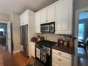 Modern kitchen featuring stainless steel appliances, a gas range, and granite countertops, adjacent to an eat-in area at 881 Park Manor Nw Ct, Marietta, GA 30064