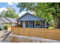 Charming single-Gathering home with a modern blue exterior and a stylish wooden fence for privacy at 85 Ollie St, Atlanta, GA 30314