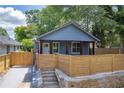 Charming single-Gathering home with a modern blue exterior and a stylish wooden fence for privacy at 85 Ollie St, Atlanta, GA 30314