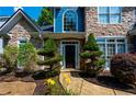 Close up of front entrance shows the landscaping, stone facade, dark front door and colorful flowerbed at 29 Sedgefield Overlook, Dallas, GA 30157
