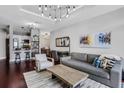 Well-lit living room featuring dark hardwood floors, stylish decor, and an open view to the kitchen and dining area at 325 E Paces Ferry Ne Rd # 1910, Atlanta, GA 30305