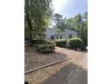 View of the home from the driveway shows the siding, unique roofline and mature trees at 3090 Alberta Dr, Marietta, GA 30062