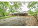 View of the house from the side yard showing brick facade and a long driveway at 4935 Golden Sw Cir, Mableton, GA 30126