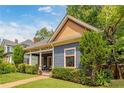 Quaint blue house exhibiting its charming architectural details and complemented by lush, mature landscaping at 694 Peeples Sw St, Atlanta, GA 30310