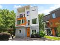 View of the home's striking modern design with balconies, orange accents and well-kept landscaping at 1463 Macklone Ne St, Atlanta, GA 30307