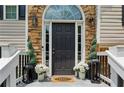 Elegant front door with decorative stone surround and potted plants at 2140 Hurt Sw Rd, Marietta, GA 30008
