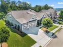 Expansive aerial view of home with three-car garage, green lawn, and mature trees at 105 Laurel Canyon Trl, Canton, GA 30114
