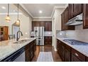 Gourmet kitchen featuring granite countertops, stainless steel appliances, and rich dark wood cabinetry at 105 Laurel Canyon Trl, Canton, GA 30114