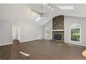 Spacious living room featuring a stone fireplace, vaulted ceiling, skylights, and elegant hardwood floors at 1252 Grist Mill Dr, Acworth, GA 30101