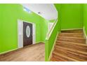 Bright foyer features a wood floor, a staircase, and lime green walls at 1030 Carriage Trace Cir, Stone Mountain, GA 30087