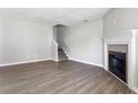 Bright living room features a fireplace, staircase, and sleek wood floors for a cozy and modern space at 5484 Denny Dr, Atlanta, GA 30349