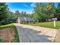 Long driveway leads to a gray single-story home, surrounded by lush trees at 69 Southern Trace Way, Rockmart, GA 30153