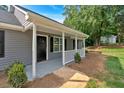 Inviting front porch with white railings, complementing the gray exterior and black door at 69 Southern Trace Way, Rockmart, GA 30153