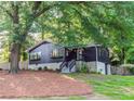 Inviting home nestled among mature trees, featuring a dark exterior and stone foundation at 706 Powder Springs Se St, Smyrna, GA 30080