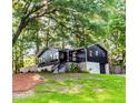 Beautifully landscaped home with a dark exterior, stone foundation, and a spacious front yard at 706 Powder Springs Se St, Smyrna, GA 30080