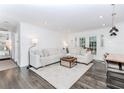 Bright living room with white walls, dark wood floors, and a cozy sectional sofa at 706 Powder Springs Se St, Smyrna, GA 30080