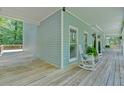 Wraparound porch showing seating, lighting, and wood floors at 14 Black Forest Run, Douglasville, GA 30134