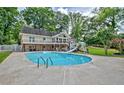 Backyard features a sparkling blue swimming pool with a slide and a spacious deck for entertaining at 522 Golfview Dr, Peachtree City, GA 30269