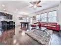 Open concept living space with dark wood floors and accents, stainless steel appliances, and comfortable seating at 5512 Cascade Run, Atlanta, GA 30336