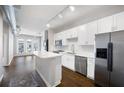 Bright kitchen features white cabinetry, stainless appliances, island, and open living space at 5300 Peachtree Rd # 3207, Chamblee, GA 30341