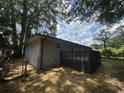Back of the house with a deck surrounded by large trees, with a small fence at 8236 Tudor Dr, Jonesboro, GA 30238