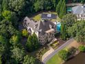 An aerial view showcases a luxury home with a basketball court, pool and lush landscaping at 11140 W Rd, Roswell, GA 30075