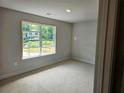 Bedroom with natural light, neutral walls and trim, and a large window overlooking the landscaped front yard at 305 Melanie Ct, Bowdon, GA 30108