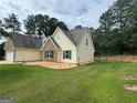 Backyard view of home showcasing landscaped grounds, fenced backyard, and manicured lawn at 521 Deadwood Trl, Locust Grove, GA 30248