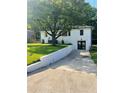 Well-manicured lawn with white brick house with updated black garage door and trim at 661 Kennesaw Se Dr, Smyrna, GA 30080