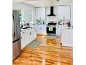 Bright kitchen featuring stainless steel appliances, white cabinets, and hardwood floors at 661 Kennesaw Se Dr, Smyrna, GA 30080