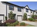 A row of identical townhomes, each boasting a one-car garage and manicured front yards at 6345 Mountain Home Se Way, Mableton, GA 30126