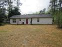 Large backyard with a red door and mature trees offering privacy at 218 Whispering Pine Circle Ne Cir, White, GA 30184