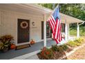 Close-up of a charming front porch with an American flag, a wreath, and white painted brick at 2377 Emory Ln, Marietta, GA 30068