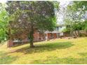 A green backyard with a red brick home and steps leading up to the back of the house at 1558 Boulderwoods Se Dr, Atlanta, GA 30316