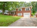 Red brick home with attached one car garage and a long driveway at 1558 Boulderwoods Se Dr, Atlanta, GA 30316
